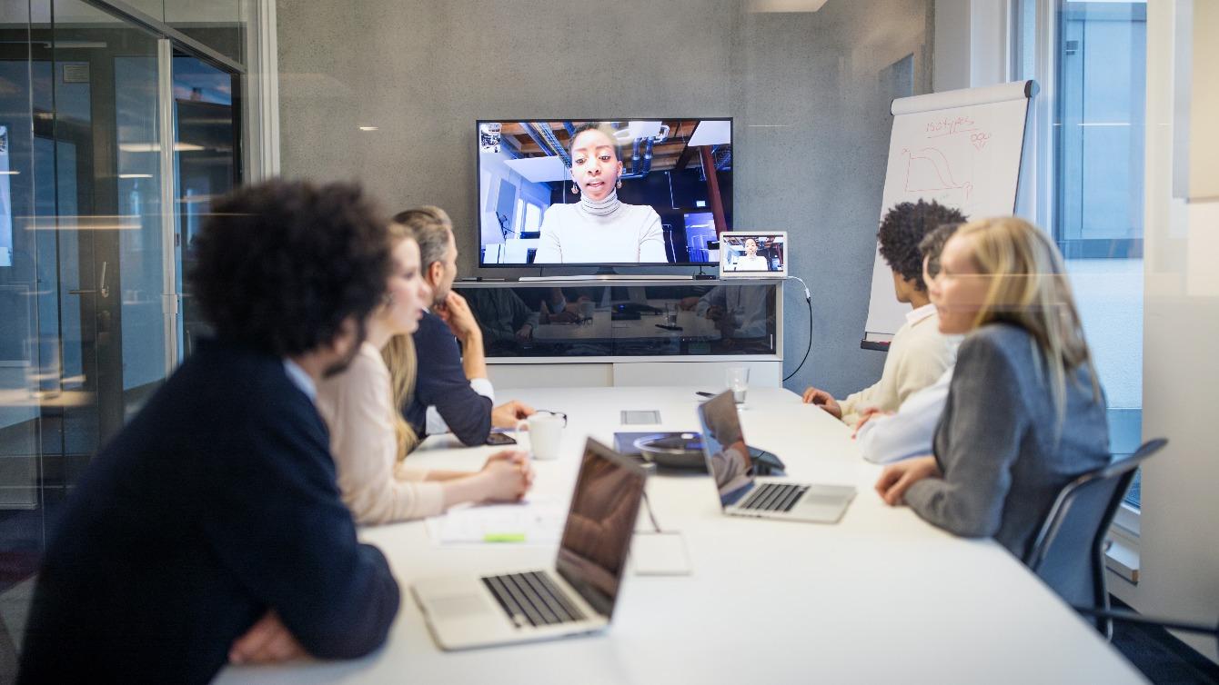 Group of coworkers in a meeting room having a virtual meeting