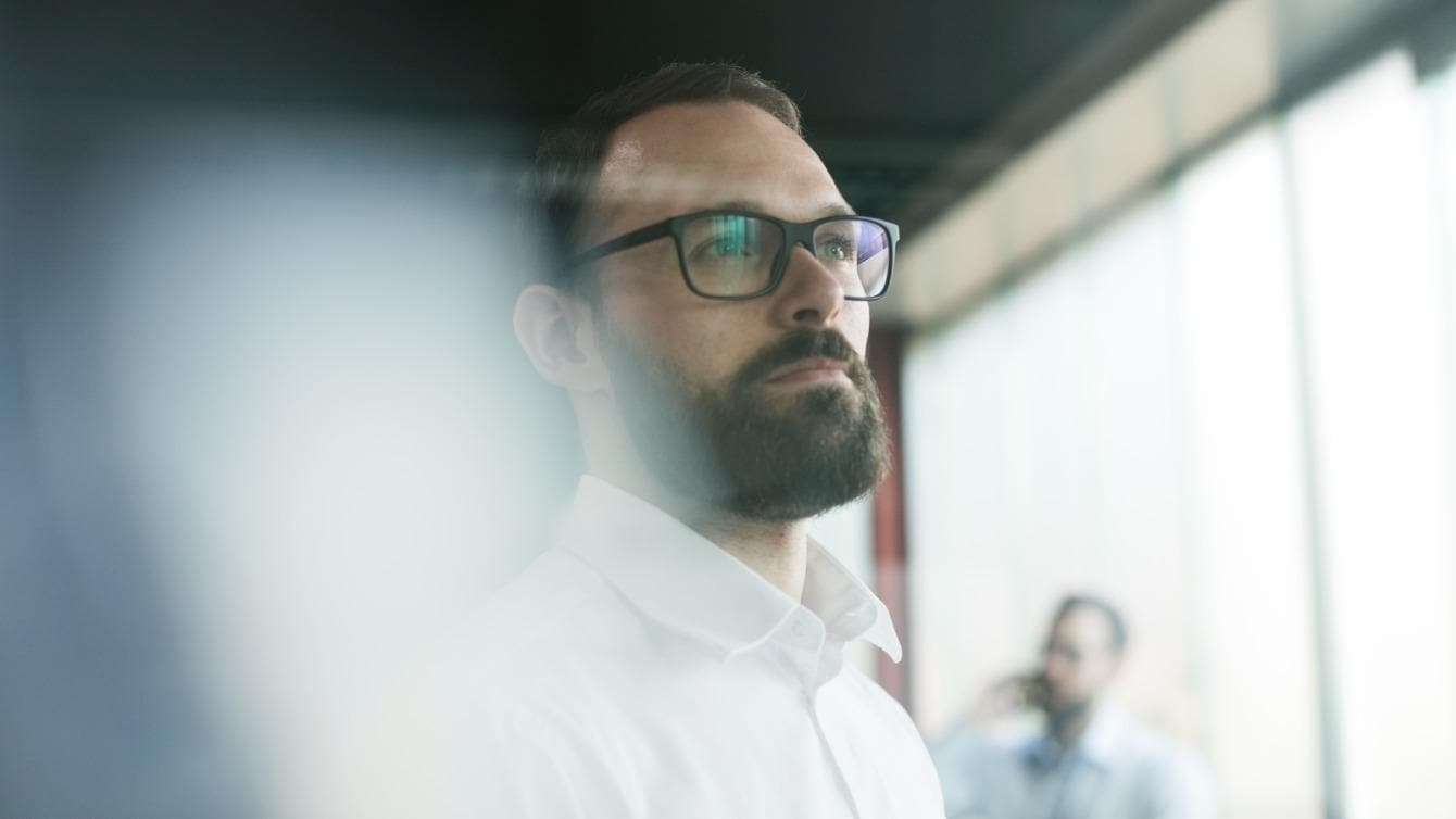 Close up of a bearded man in an office meeting room